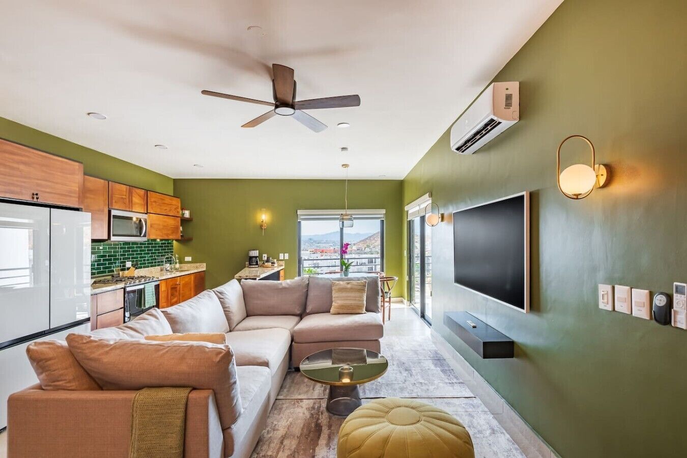 Ein modernes Wohnzimmer mit einem Ecksofa, einem Couchtisch und einem an der Wand montierten Fernseher.