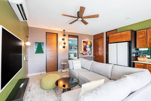 A modern living room with a sofa, a coffee table, and a ceiling fan.