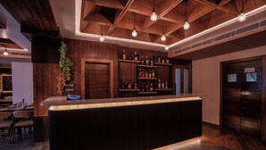 A bar area with wooden paneling, a counter, and hanging light fixtures. - Evara Hills, Gangtok (Gangtok)