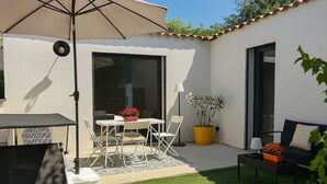 A patio with a table and chairs, a yellow potted plant, and a sofa. - House Garden Pool – The Cherry Tree (Venelles)