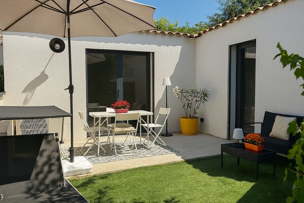 A patio with a table and chairs, a yellow potted plant, and a sofa. - House Garden Pool – The Cherry Tree (Venelles)