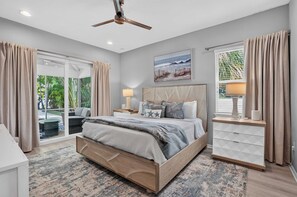 Un dormitorio moderno con una cama grande, un ventilador de techo y vistas al exterior.