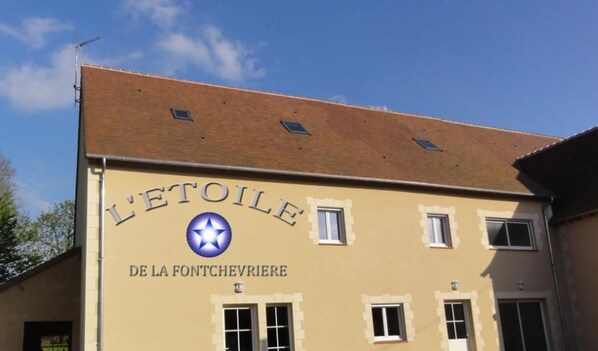 A building with a sign reading "L'ETOILE DE LA FONTCHERIERE". - Spacious Room with Private Bath, Shared Kitchen, and Breakfast Included in Neuvy-Saint-Sépulchre (Neuvy-Saint-Sépulchre)