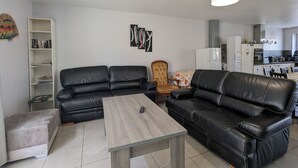 Una sala de estar moderna con un sofá seccional, una mesa de centro y una estantería.