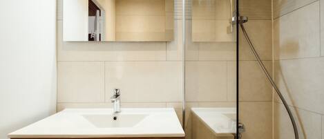 A bathroom with a wooden vanity, a mirror, a shower, and a bathtub.