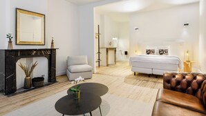 A modern living room with a fireplace, sofa, and a dining area. - Junior Suite in The Heart of Antwerp (Antwerpen)