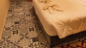 A hotel room with a large bed, a small table, two chairs, a desk, and a window with curtains. - HOTEL LA VALLEE DES KASBAHS CHEZ ILYAS (Tinghir)