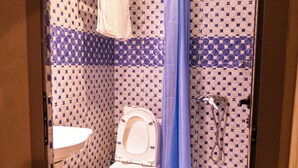 A bathroom with a toilet, sink, shower, and patterned walls. - HOTEL LA VALLEE DES KASBAHS CHEZ ILYAS (Tinghir)