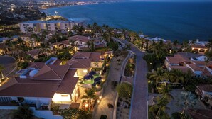 Zona residencial costera con casas, palmeras y vista al océano.