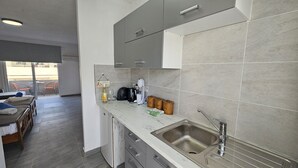 A modern kitchen with a marble countertop, stainless steel sink, and a coffee machine. - 137 AN - Stay ZEA Studio (Ayia Napa)