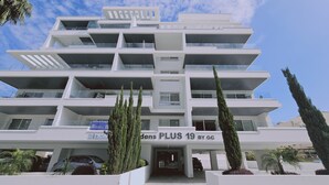 Ein mehrstöckiges Hotel mit modernem Design, mit Balkonen auf jeder Etage und einem markanten Eingang.