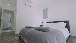 Ein modernes Hotelzimmer mit einem aufgeräumten Bett, einer Nachttischlampe und einem großen Fenster.
