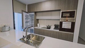 A modern kitchen with a built-in oven, a toaster, and a sink with a faucet. - 132 LCA - Stay Diamond Apartment (Larnaca)
