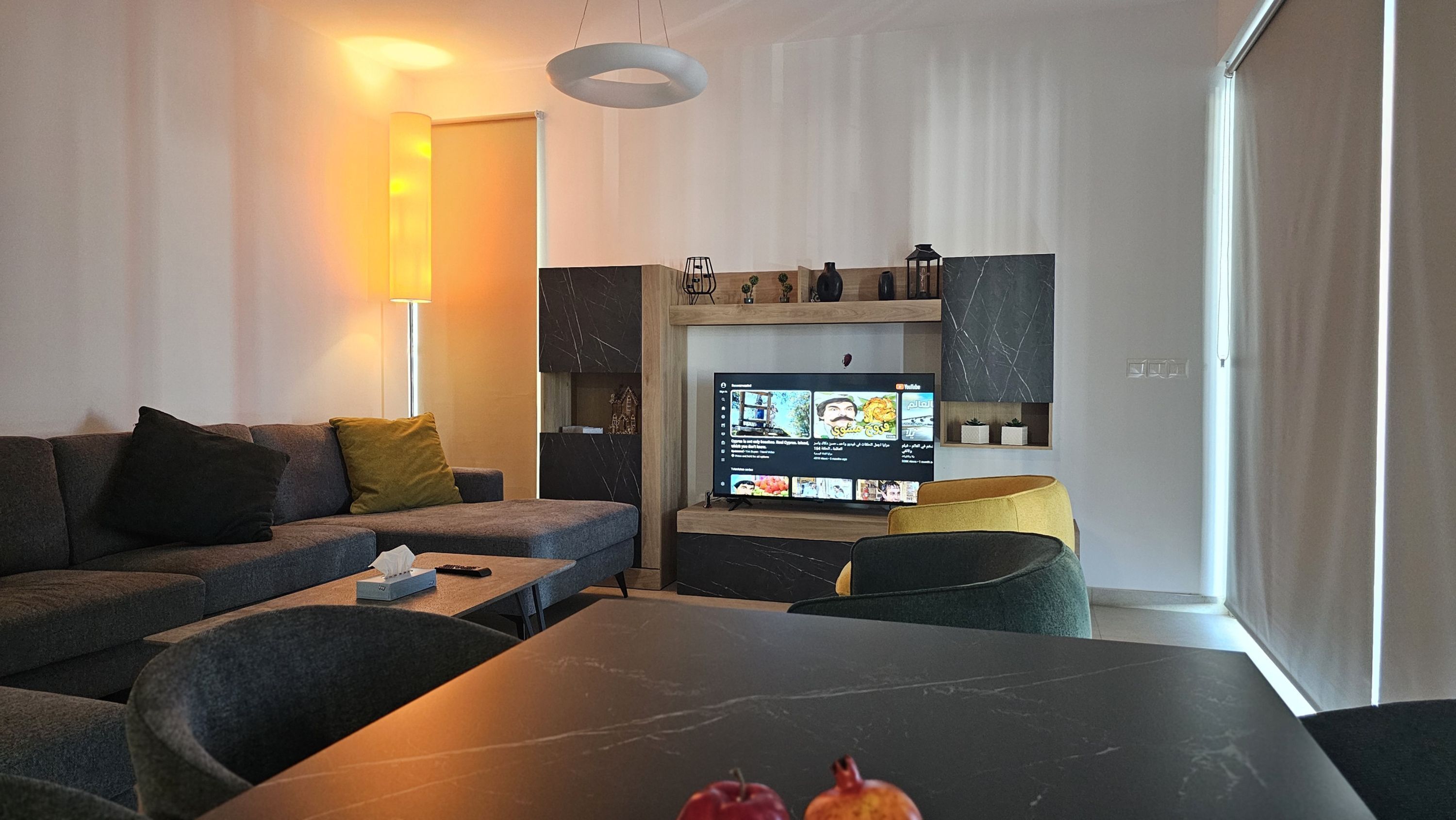 Una sala de estar moderna con un sofá, una mesa de centro y un televisor.