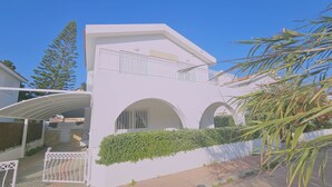 A white two-story building with a balcony, arched windows, and a gated entrance. - 124 PRO - Stay Princess Villa (Paralimni)