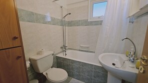 Un baño con inodoro, ducha y lavamanos.