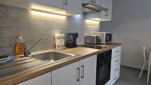 A modern kitchen with a stainless steel sink, a coffee maker, a microwave, and a dishwasher. - 145 NIC - Stay Historia Apartment (Nicosia)