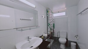 Une salle de bain moderne avec un lavabo en verre, des toilettes et un espace douche.
