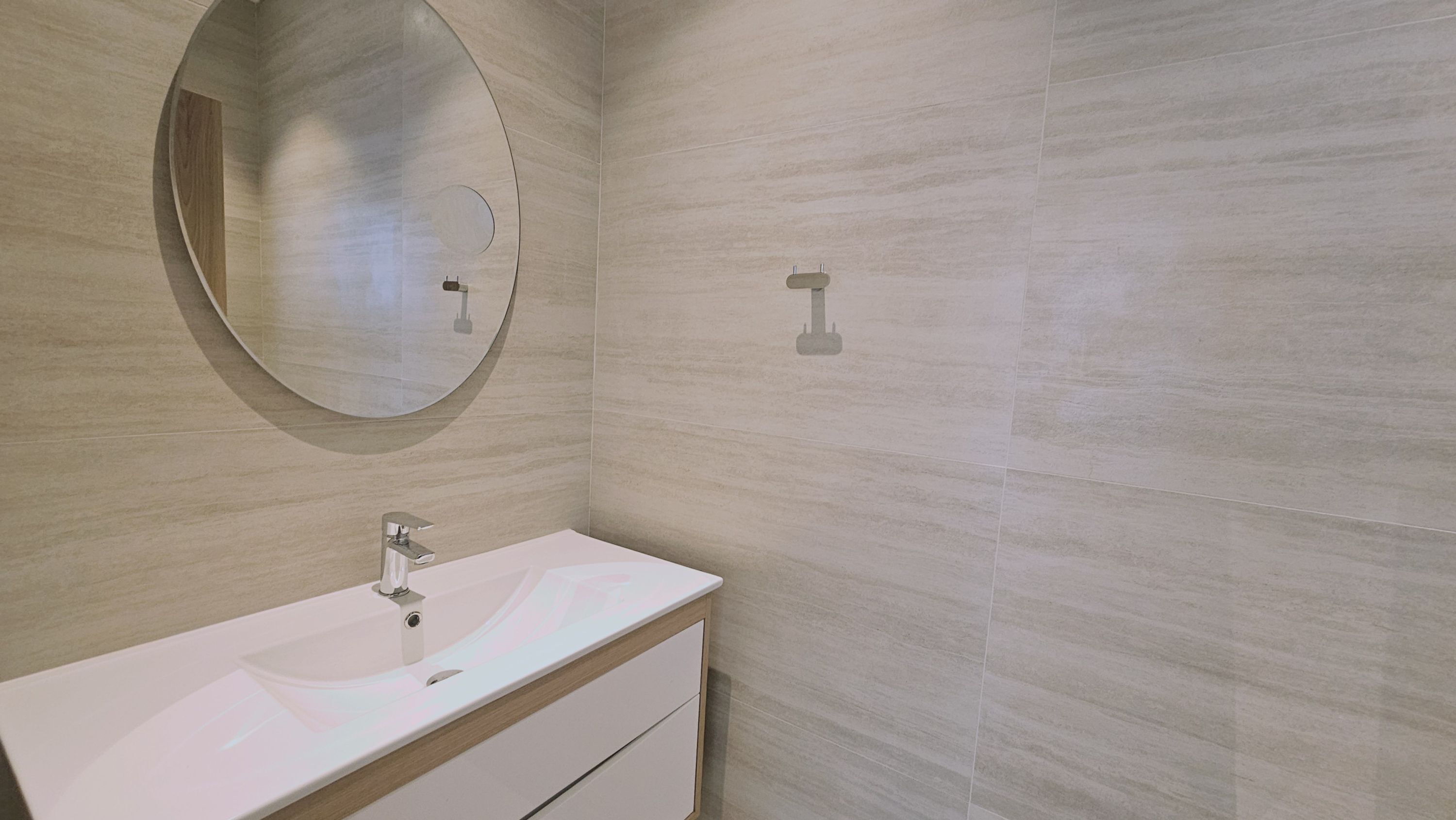 Ein Badezimmer mit Waschbecken, Spiegel und Toilette.