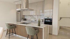 A modern kitchen with a marble countertop, two bar stools, a built-in oven, and a stainless steel range hood. - 146 5 AN - Stay Oasis Luxury Villa (Ayia Napa)