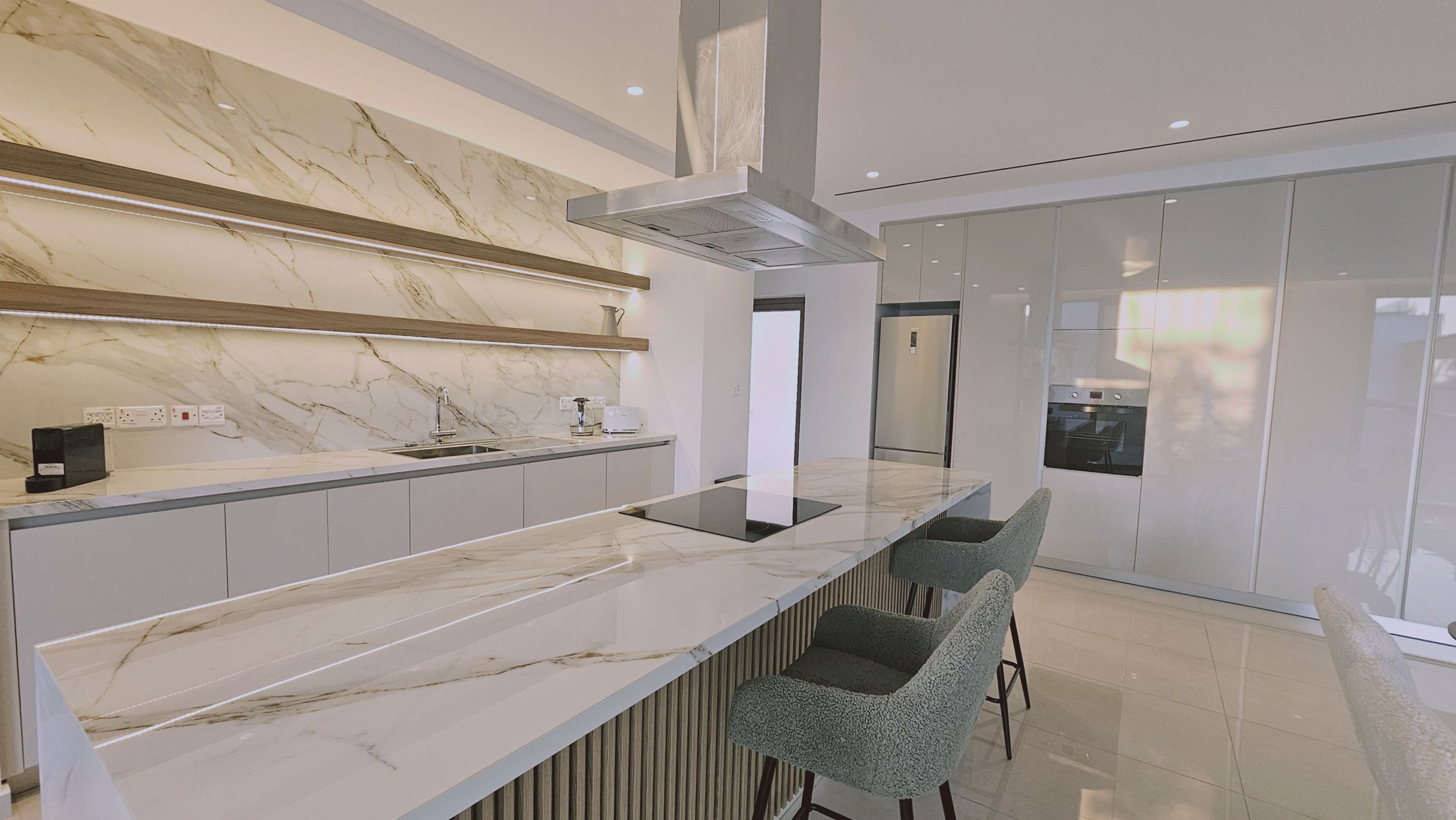 A modern kitchen with a marble countertop, built-in appliances, and a sleek design.