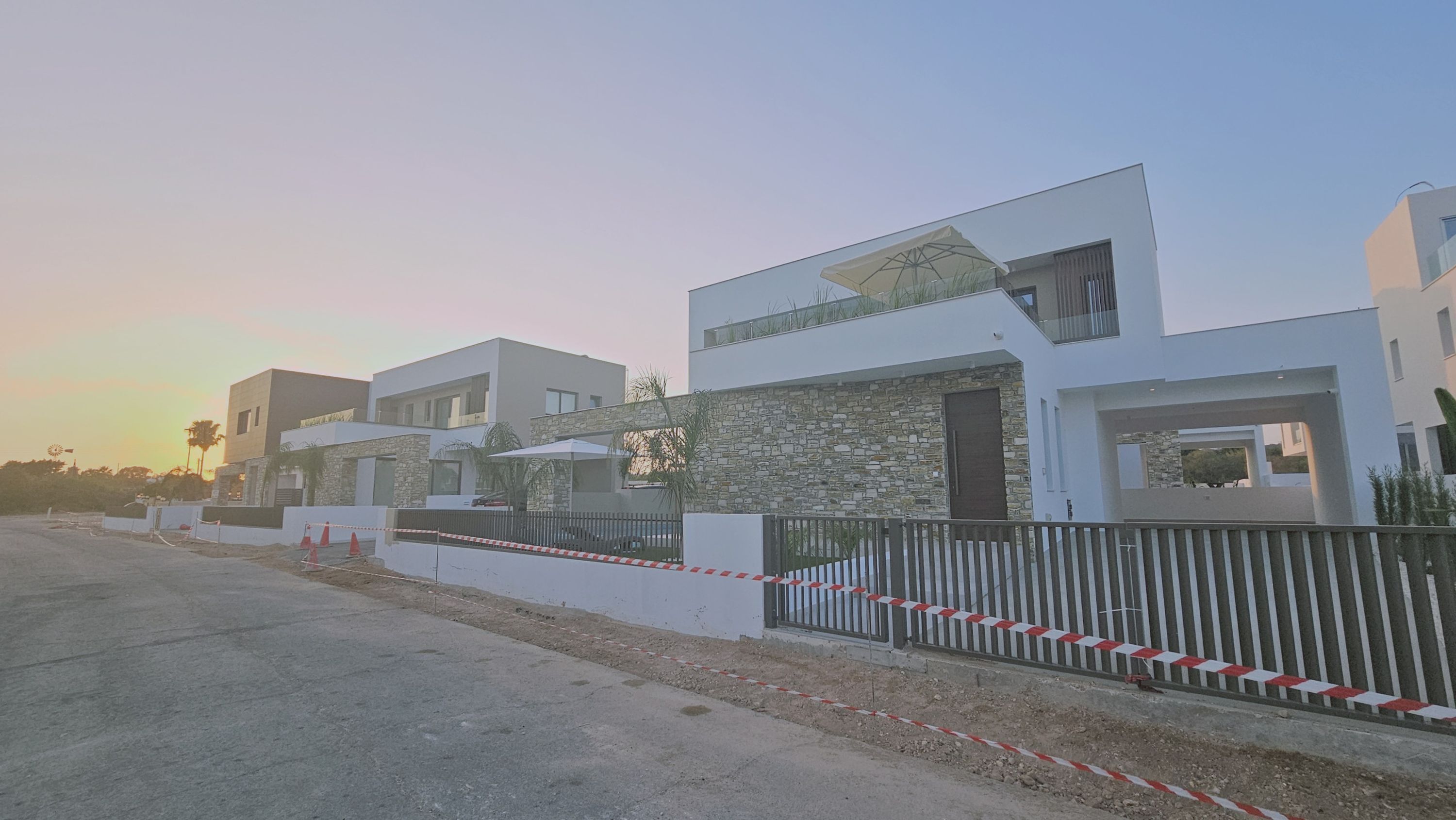 Uma área residencial moderna com casas contemporâneas, fachadas de pedra e grandes janelas.