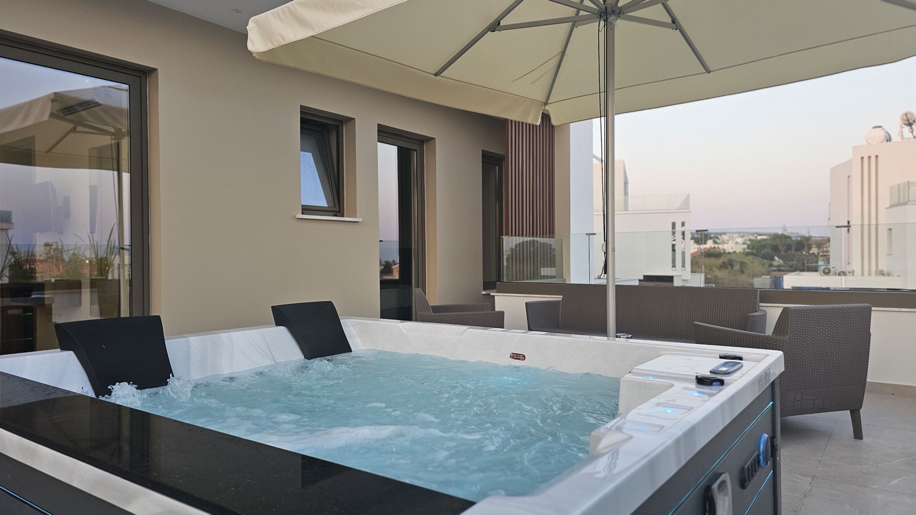 A hot tub on a balcony with a view of the city.