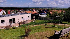 Un barrio residencial con casas, paneles solares, un jardín y un banco.