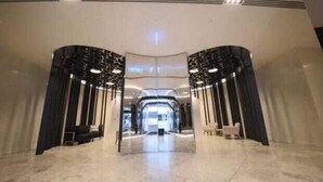 A spacious lobby with a central open area and symmetrical black and white decor.