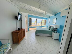 A bedroom with a bed, bedside table, and a TV mounted on the wall.