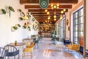 Enjoy a meal in our inviting dining area with wicker chairs, decorative art, and pendant lights.