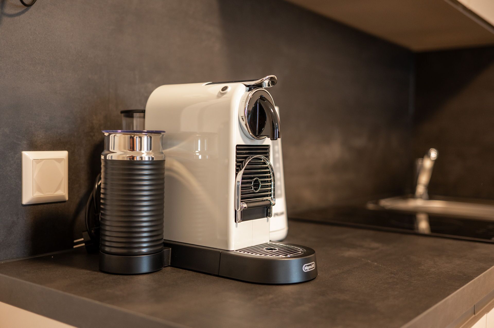 A coffee machine on a kitchen counter with a water dispenser and a coffee pot.