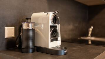 A coffee machine on a kitchen counter with a water dispenser and a coffee pot.