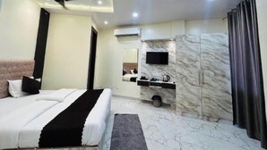 Una camera da letto moderna con un letto, una ventola a soffitto, una TV montata a parete e un armadio con decoro marmorizzato.