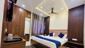 Una camera da letto con un letto grande, un'armadiatura in legno e una ventola a soffitto.