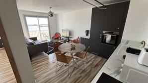 Una cocina moderna con comedor, sofá y vistas al exterior.