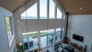 Un espacio habitable amplio con ventanas grandes, una chimenea y un televisor de pantalla plana.