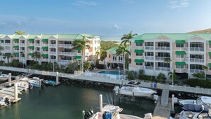 Un hôtel doté de nombreux balcons, d’une piscine et d’un port de plaisance avec des bateaux.