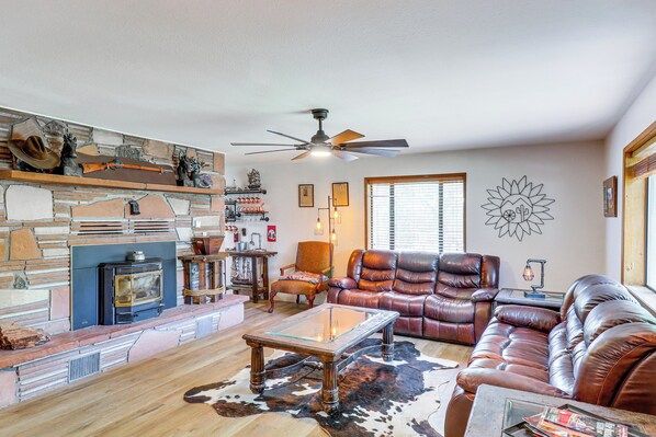 Cozy living room with a fireplace, leather sofa, armchairs, and a coffee table.
