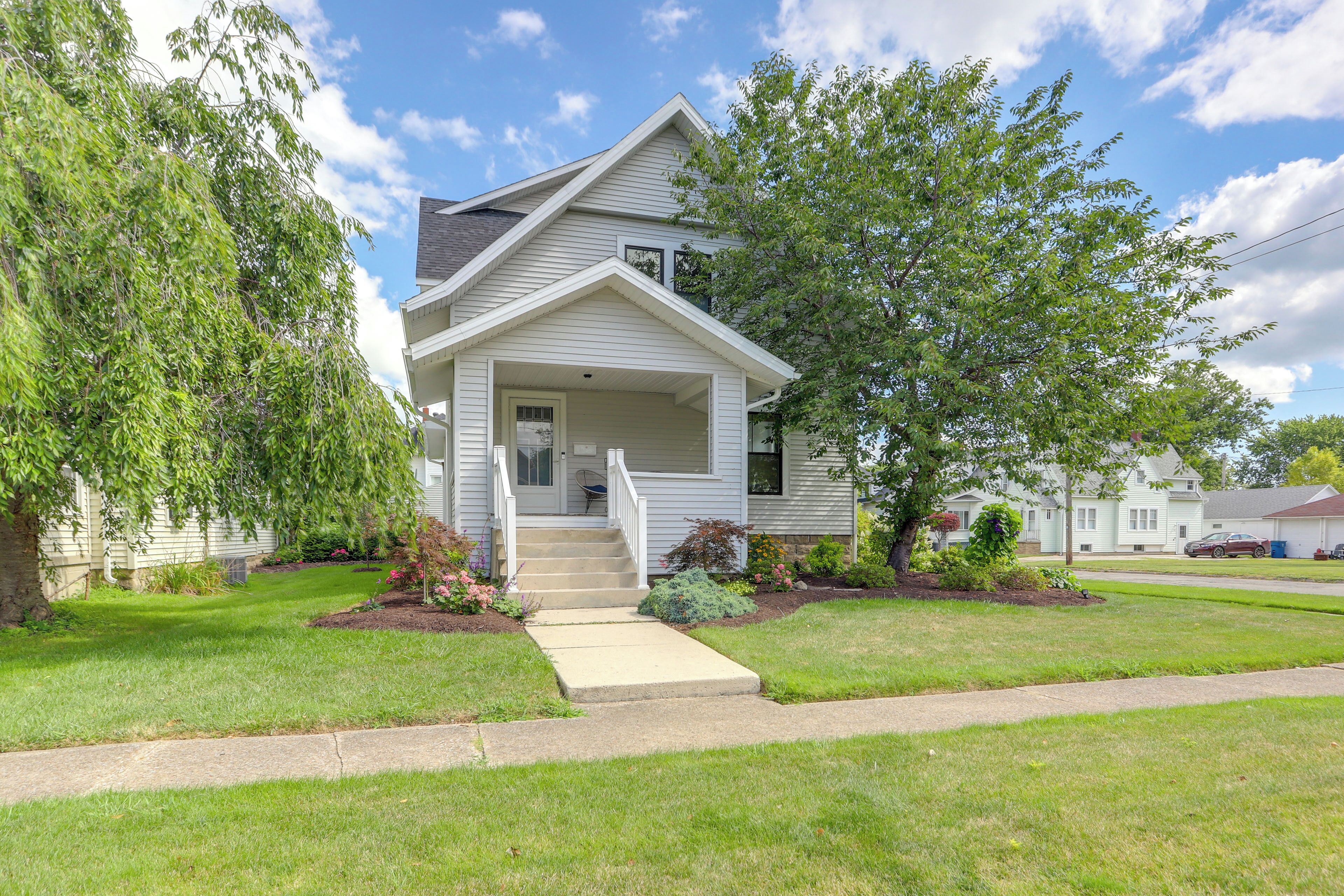 A single-story house with a front porch, a small front yard, and a driveway leading to the entrance.