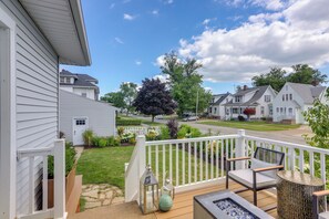A residential deck with outdoor seating, a fire pit, and a view of a suburban neighborhood. - Port Clinton Home w/ Lake View - Walk to Beach! (Port Clinton)