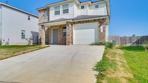 A two-story house with a garage, a driveway, and a wooden fence in the background. - San Antonio Home w/ Pool Access: 11 Mi to Seaworld (San Antonio)