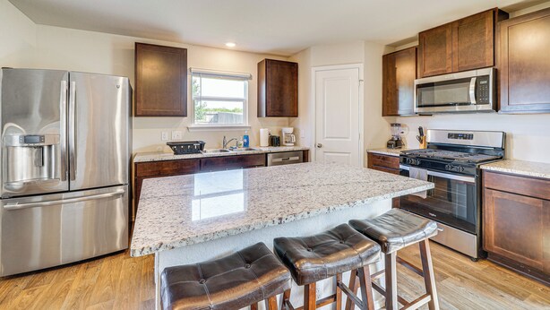 A modern kitchen with stainless steel appliances, a granite countertop, and wooden cabinets. - San Antonio Home w/ Pool Access: 11 Mi to Seaworld (San Antonio)