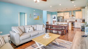A modern living room with a sofa, coffee table, and dining area. - Close to Beaches: Palm Coast Home w/ Deck! (Palm Coast)