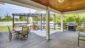 An outdoor patio with a wooden ceiling, a pergola, a table with chairs, and a barbecue grill. - Close to Beaches: Palm Coast Home w/ Deck! (Palm Coast)