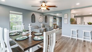 A dining area with a wooden table, white chairs, and a ceiling fan. - Brownwood Family Home - 2 Mi to Public Marina! (Brownwood)
