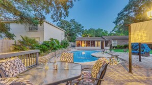 A backyard with a swimming pool, outdoor seating, and a patio area. - Fort Walton Beach Home w/ Pool: 5 Mi to Beach! (Fort Walton Beach)