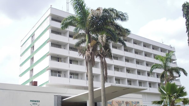 Un hôtel à plusieurs étages, doté d’un toit plat et d’une enseigne indiquant « Premier Hotel ».