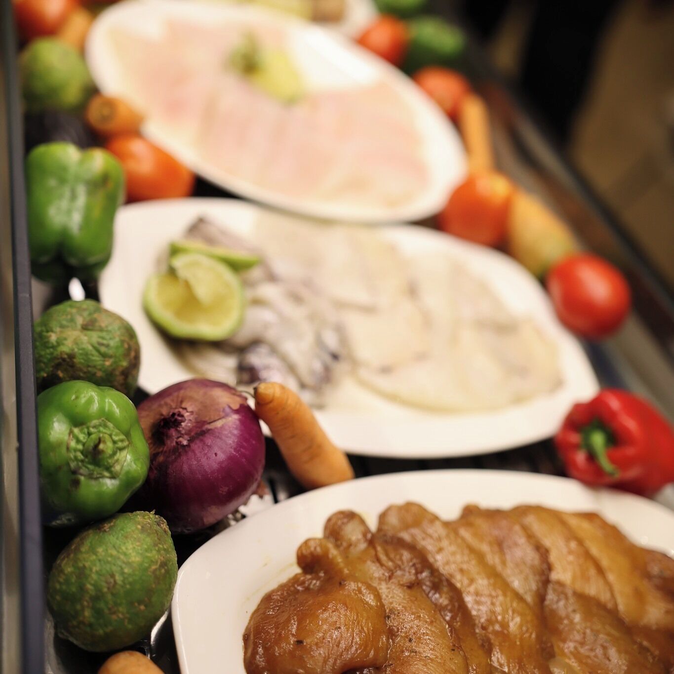 A variety of fresh produce including tomatoes, onions, and peppers on display.