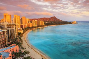 A coastal cityscape with high-rise buildings, a beach, and a mountain in the background. - Ocean and Sunset Marina Views at the Ilikai Hotel w/Great Building Amenities (Honolulu)